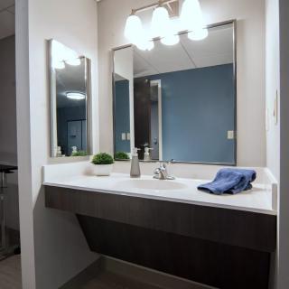 A modern bathroom with a double sink, mirrors, and stylish lighting.