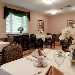 An elegant dining room with neatly arranged tables, adorned with flowers and stylish tableware.