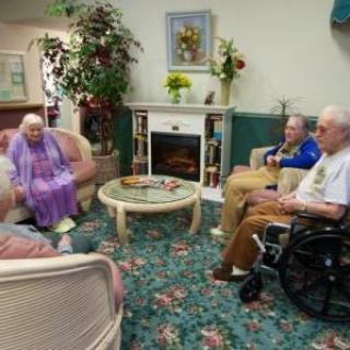 Elderly individuals socializing in a comfortable nursing home setting.
