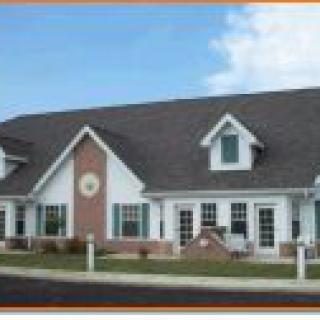A suburban-style residential building with a gabled roof and multiple windows.