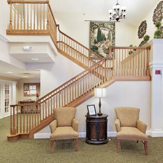 A welcoming lobby area with a wooden staircase and comfortable seating.