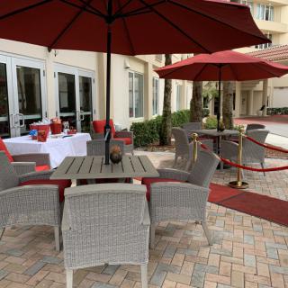 Outdoor patio area with wicker furniture and red umbrellas.