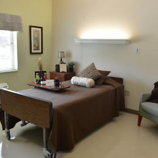 A well-designed hospital room featuring a single bed, comfortable seating, and calming colors.