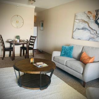 A cozy living room with a sofa, coffee table, and adjacent dining area.