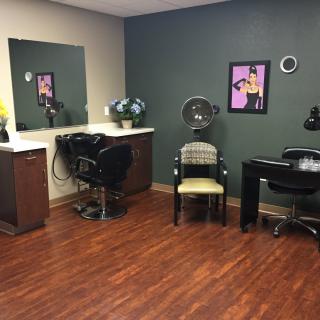 A cozy and well-equipped hair salon room with styling stations and hairdryers.