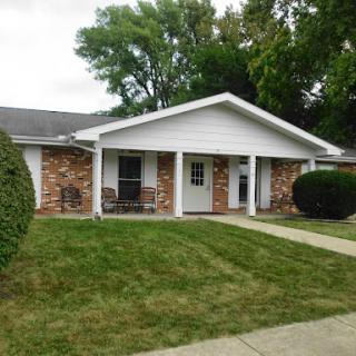 A charming residential home with a well-maintained front yard.