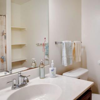 A clean and tidy bathroom with a sink, mirror, and towels.