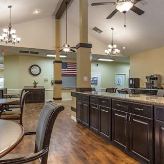 A spacious kitchen and dining area with elegant lighting and wooden flooring.