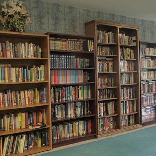 A cozy library with wooden bookshelves filled with a variety of books.