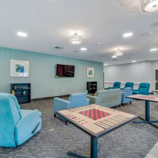 A modern lounge area with comfortable chairs and game tables.