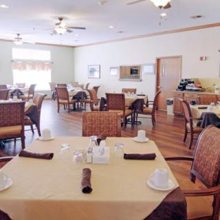 An empty dining room with neatly set tables and chairs.
