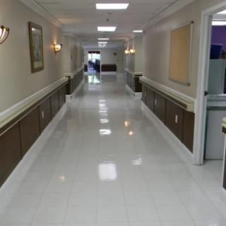 A clean and bright hospital corridor with polished floor tiles.