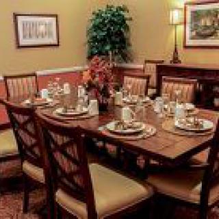 A beautifully set dining table in a warmly decorated dining room.