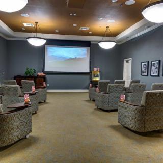 A small, cozy movie theater with comfortable seating and a large screen.