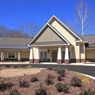 A modern residential facility with a symmetrical design and landscaped surroundings.