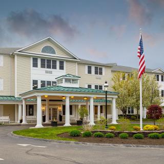 A welcoming residential building with a flagpole and well-maintained landscaping.