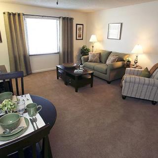 A cozy living room with a sofa set, coffee table, and dining area.