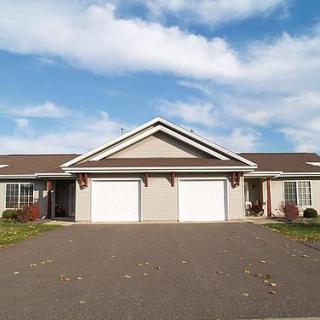 Front view of a suburban duplex with two garages and a shared driveway.