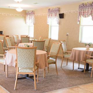 A spacious dining area set up for an event with soft lighting and elegant decor.