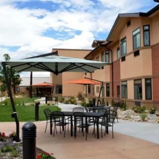 An outdoor patio area with tables and umbrellas set against a modern building.
