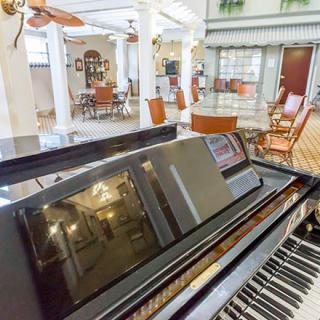 A spacious lobby with a grand piano and comfortable seating.