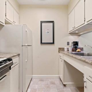 A compact kitchen with white cabinets and essential appliances.
