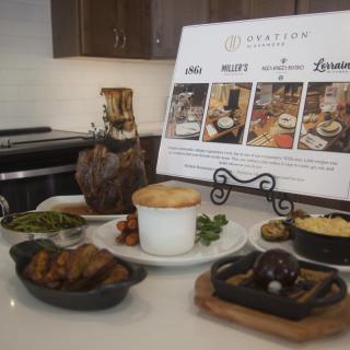 A gourmet meal setup featuring various dishes alongside a menu display on a restaurant table.
