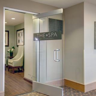 Entrance to a spa with a glass door and waiting area.