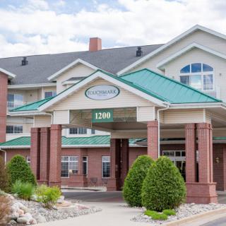 A welcoming hotel entrance with green roofs and landscaped surroundings.