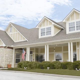 A large residential house with a porch and multiple gables.