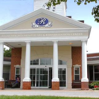 A building entrance with four large columns and a logo above the doors.
