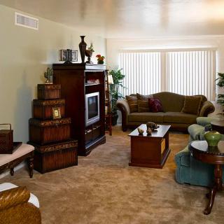 A cozy living room featuring a sofa, television, and various pieces of furniture.