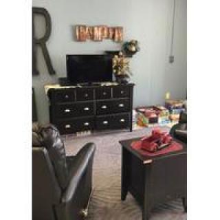 A cozy living room setup with a television atop a dresser, surrounded by elegant decor.