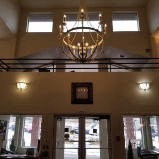 Interior view of a building lobby with chandelier and balcony.