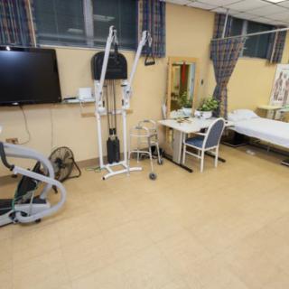 A rehabilitation room equipped with exercise machines and medical equipment.