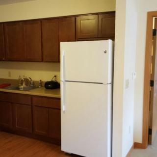 A kitchen interior featuring wooden cabinets and a white refrigerator.