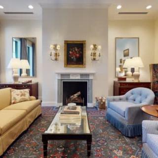 A well-decorated living room featuring a fireplace, sofas, an armchair, and a coffee table.