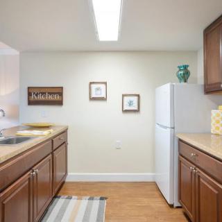 A tidy kitchen with wooden cabinets and a white refrigerator.