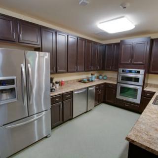 A modern kitchen with dark wood cabinets and stainless steel appliances.
