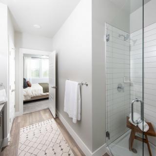A modern, minimalist bathroom with a glass shower and elegant decor.