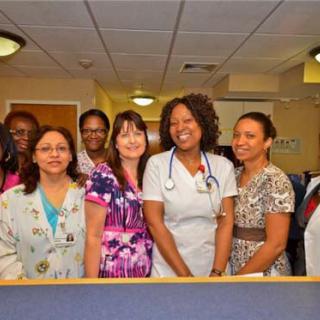 A group of medical professionals smiling together in a hospital setting.