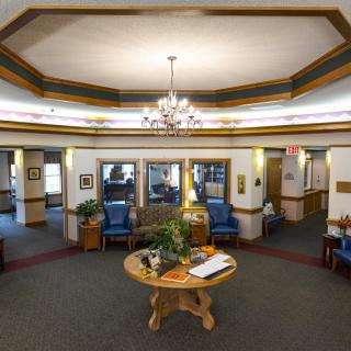 A spacious lobby with a chandelier, comfortable seating, and decorative plants.