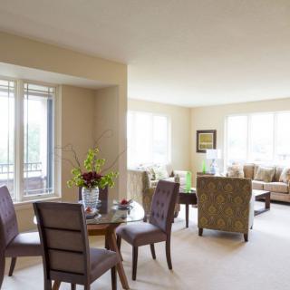 A spacious living and dining area with elegant furniture and large windows.
