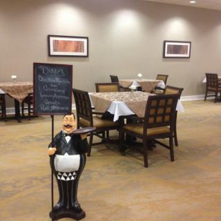 An empty restaurant dining area with neatly set tables and a menu sign at the entrance.