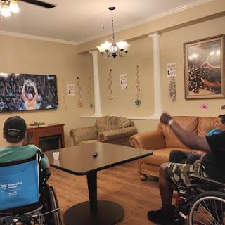 Residents enjoying a sports game together in a cozy community lounge.