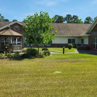 A view of a residential building with a well-maintained garden and spacious lawn.