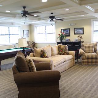 A cozy living room with sofas and a pool table.