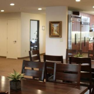 A modern dining area with wooden tables and chairs, decorated with small plants.