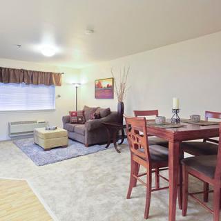 A cozy living and dining space with a sofa, table, and chairs, accented by home decor.