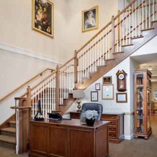 A home office with a wooden staircase and decorative elements.